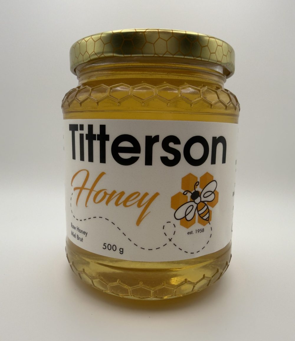 A 500 g jar of Titterson raw honey in a honeycomb patterned jar.